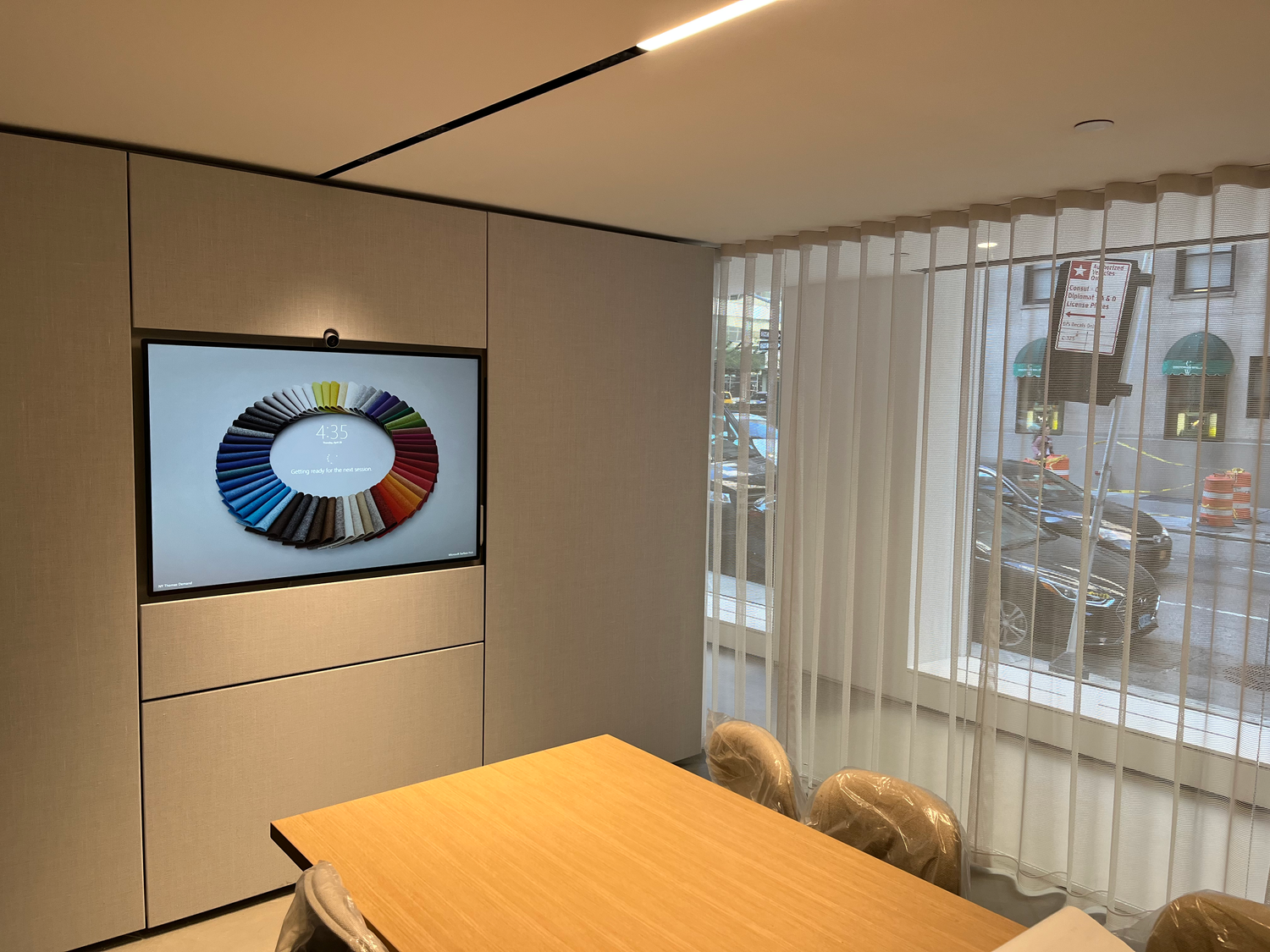 AMCS Tech Group commercial AV install — wall-mounted Microsoft Surface Hub in a modern showroom
